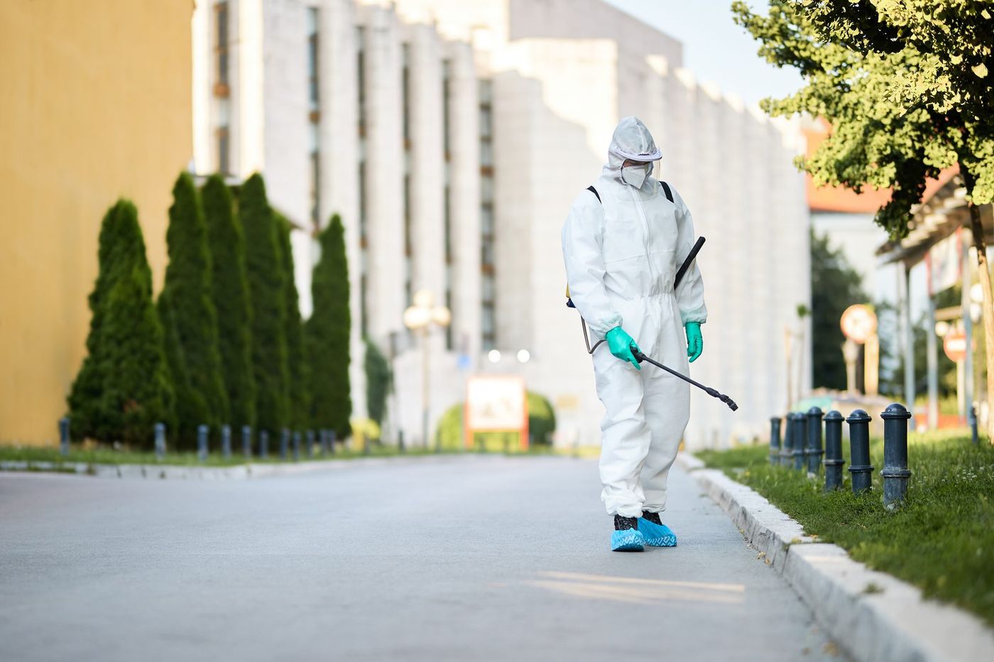 AdsFlair pest control client in protective coveralls carrying out a treatment spray