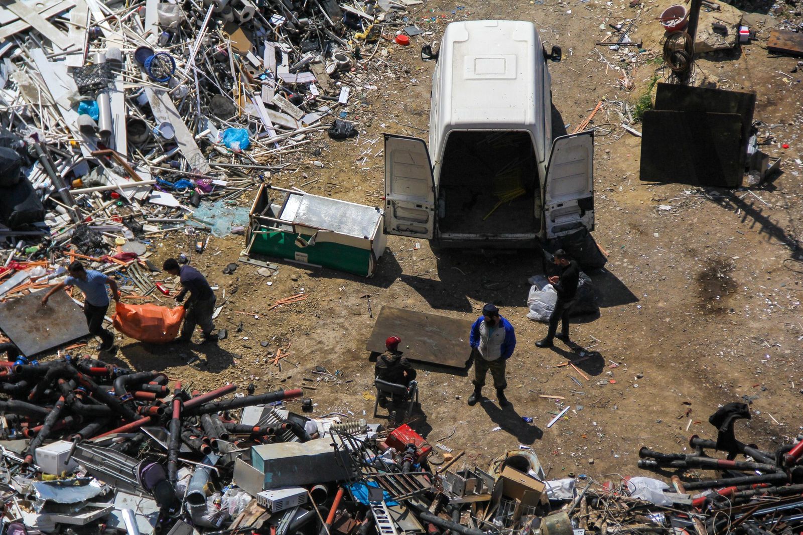 Junk removal crew clearing scrap and waste into a removal van